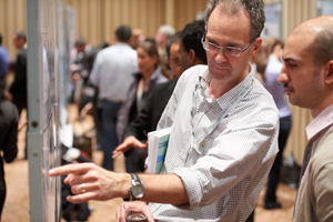 Candid shot of conference attendees examining poster